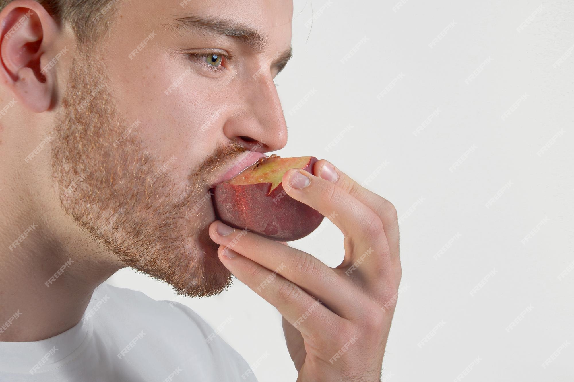 man eating a peach